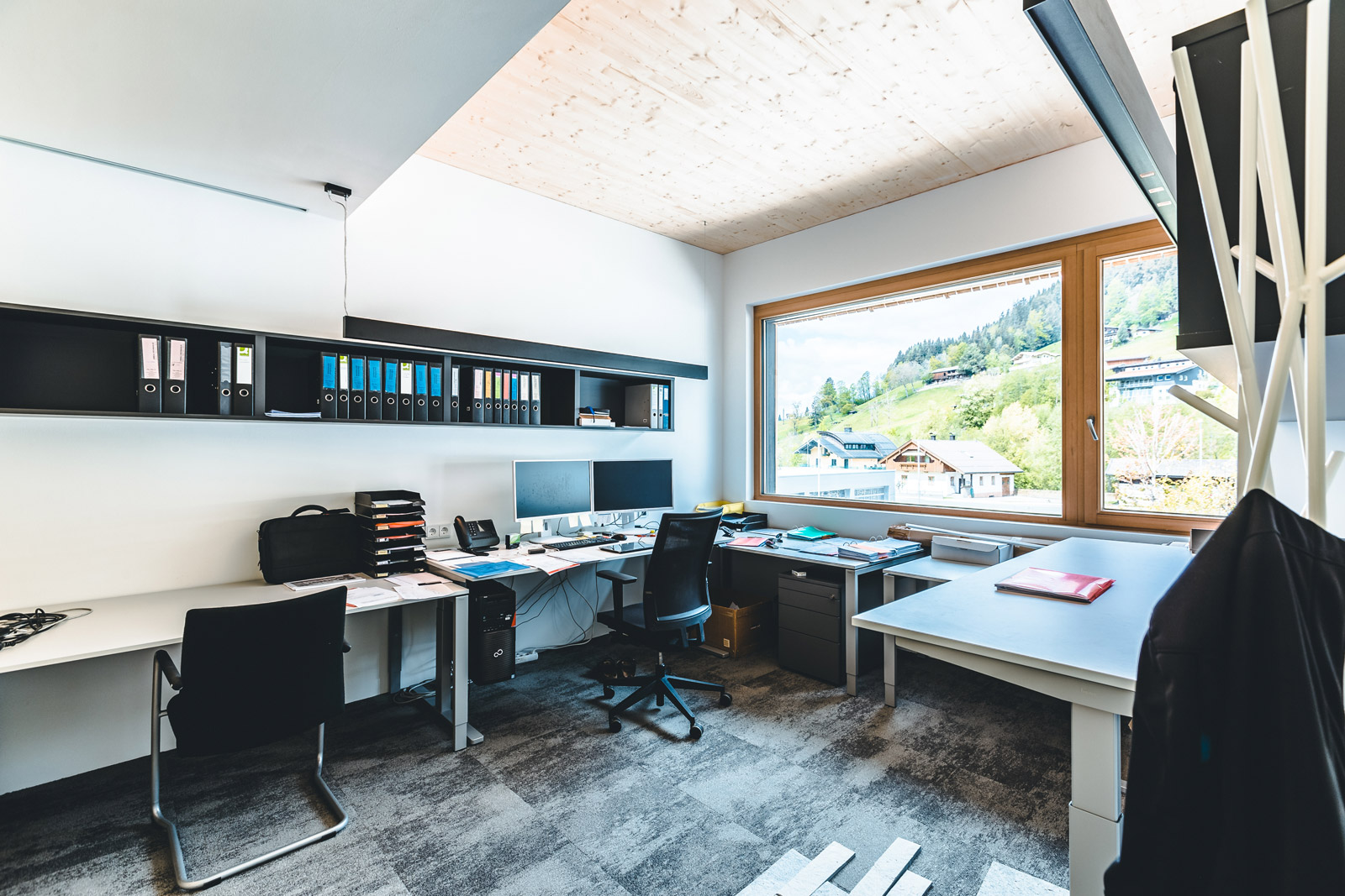 Gemeinschaftsküche mit Holzdecke, Fenster und dunkler Küchenzeile